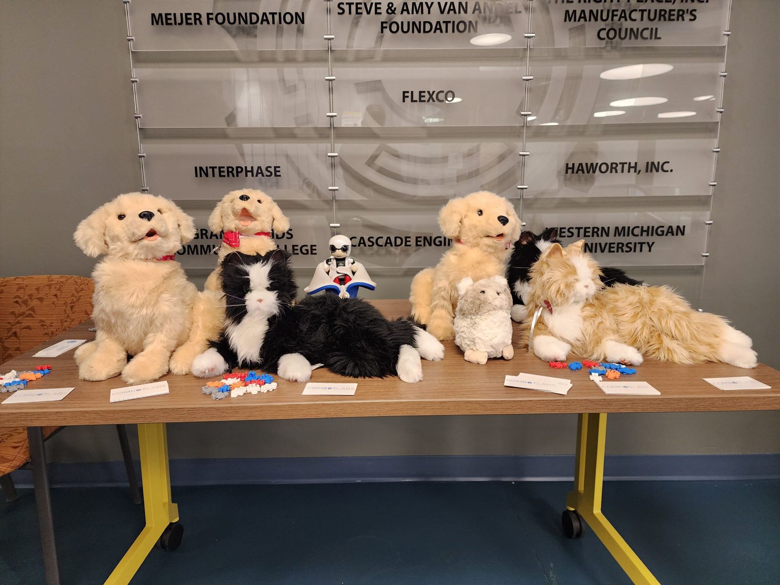 Robot pets lined up on a table at a lab event